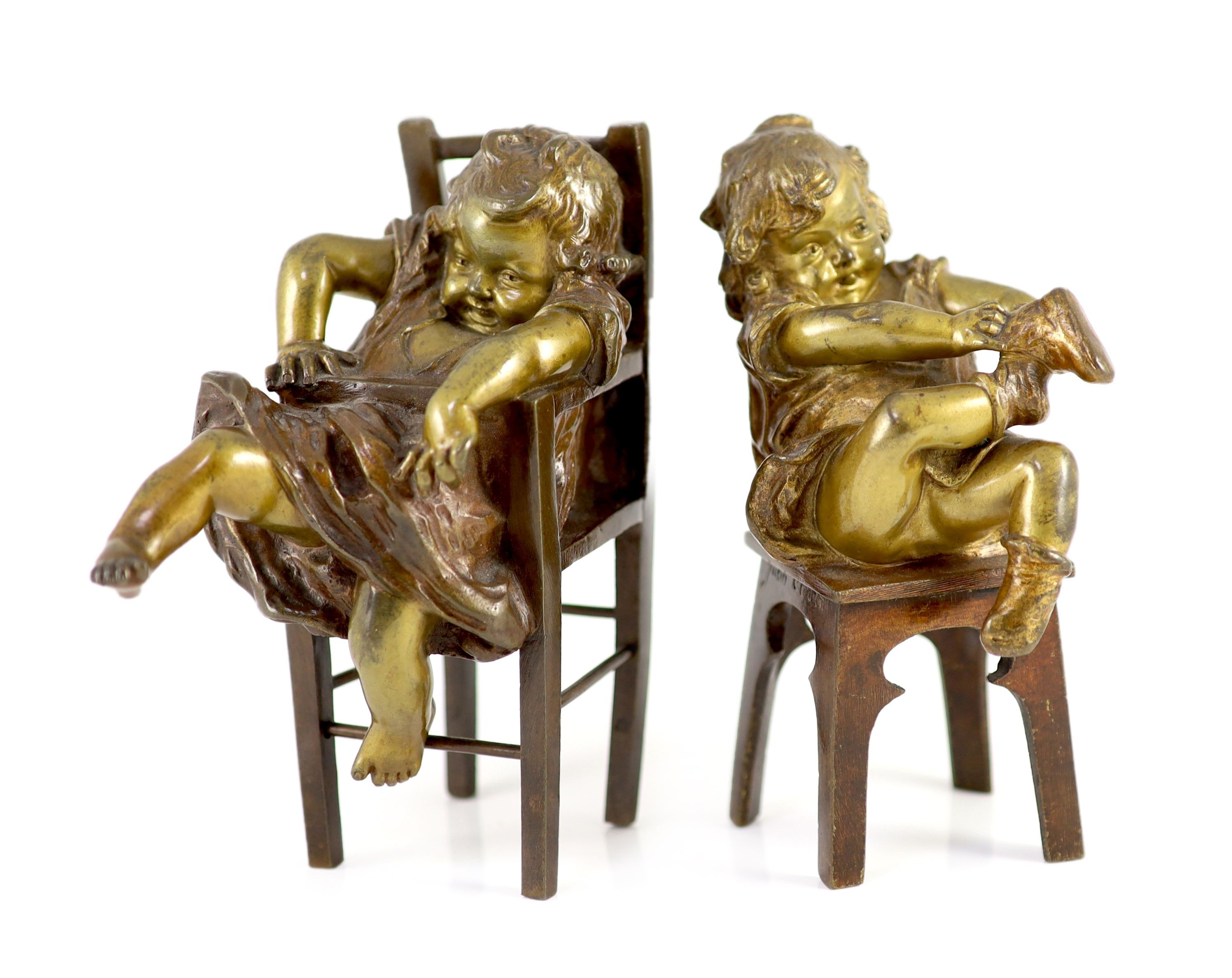 After Joan Clarà (1875 - 1958). A pair of bronze models of girls playing on chairs, height 15.5cm